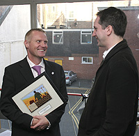 Jonathan Bellamy presenting Mayor Mark Meredith with a picture gift showing new building taking place